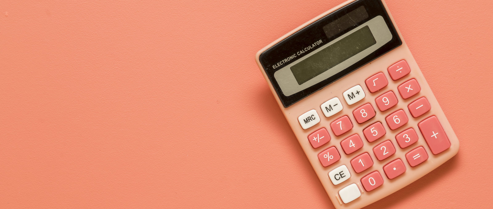 Photograph of a salmon-coloured calculator on a salmon-coloured background