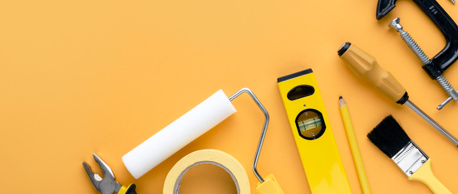 Photo of various DIY tools arranged on a dark yellow surface