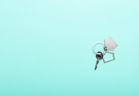Silver house key on a keyring with a house-shaped fob.