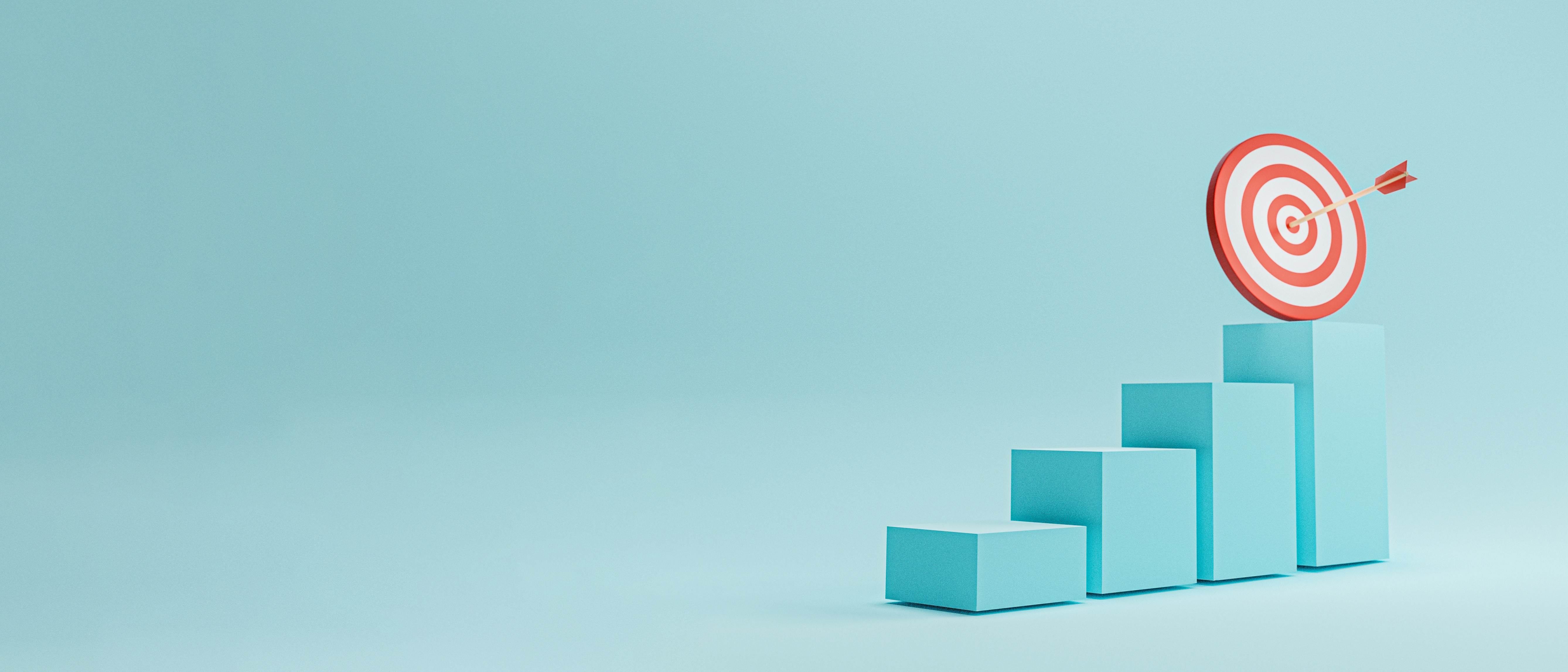 Photo of a 3 dimensional bar chart made of turquoise blocks increasing in height from left to right. Above the highest block is a target with an arrow stuck right in the centre.