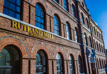 Exterior shot of Rutland Mills apartments with the sign