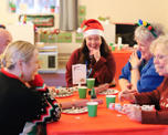 Photo of people sitting around a table with Christmas decorations on