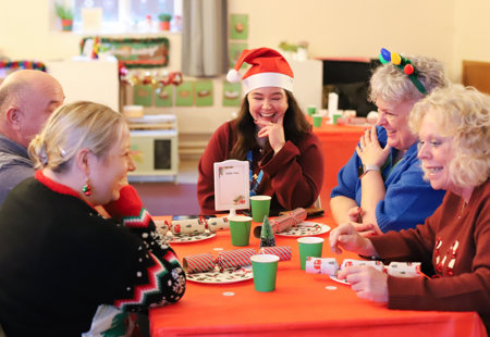 Photo of people sitting around a table with Christmas decorations on