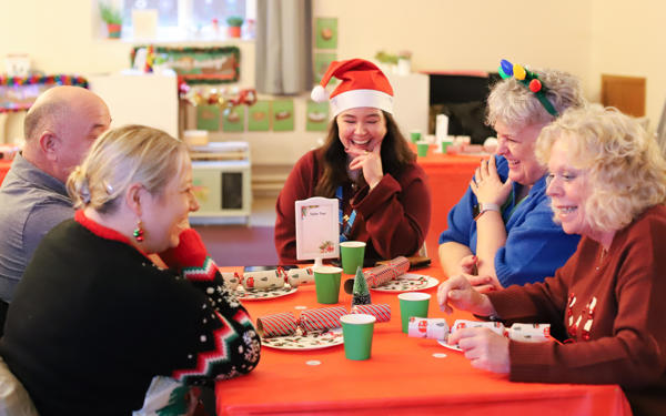 Photo of people sitting around a table with Christmas decorations on