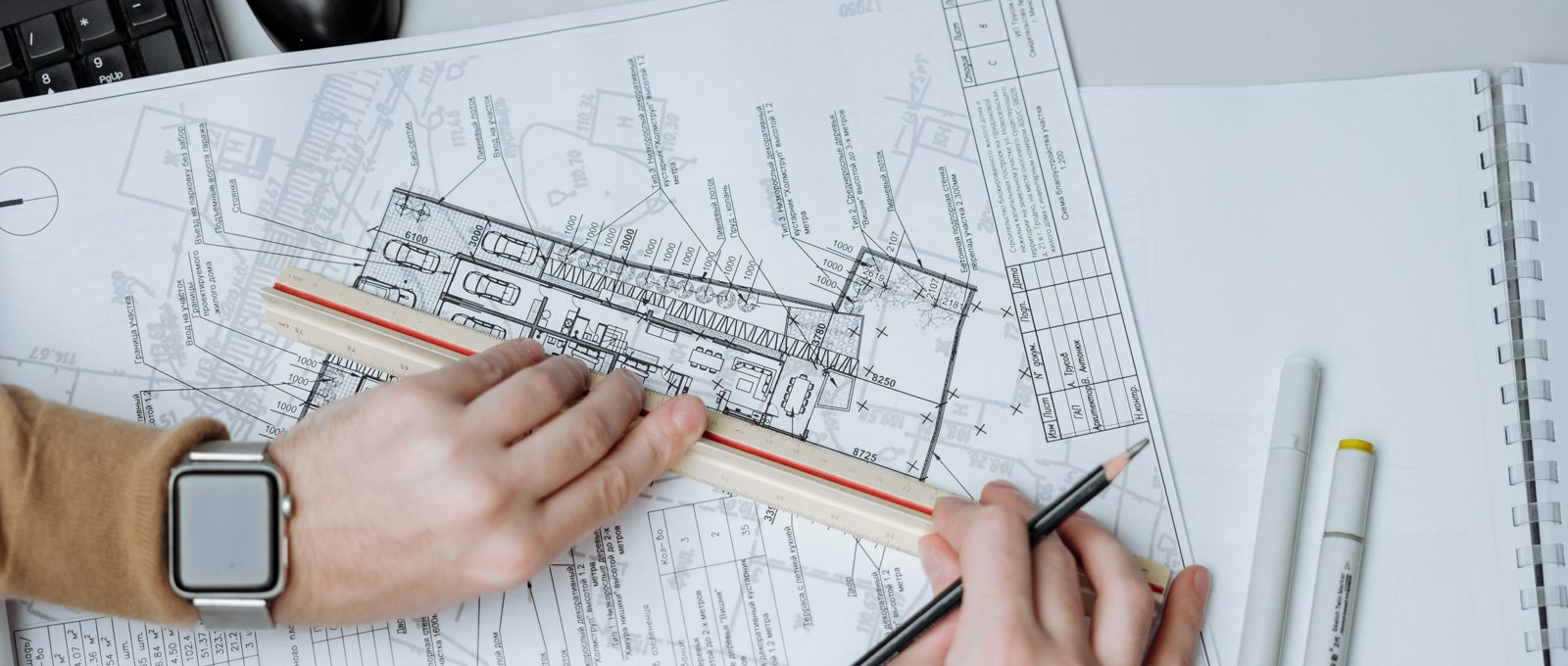 Close up photograph of someone working on architectural blueprints