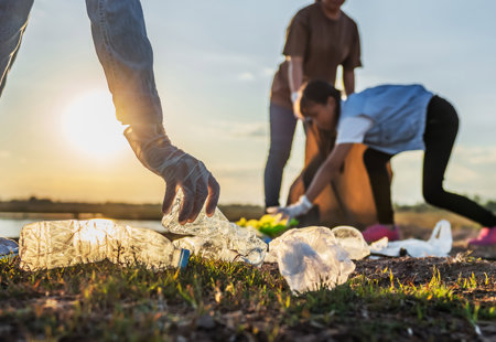 People Volunteer Keeping Garbage Plastic Bottle Into Black Bag Park Near River Sunset