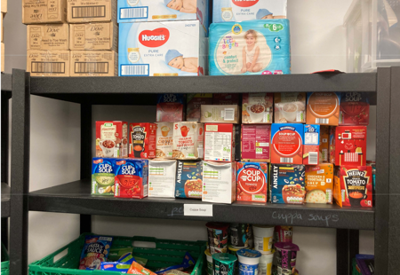 Photo of food items and household products on shelving in a storage area