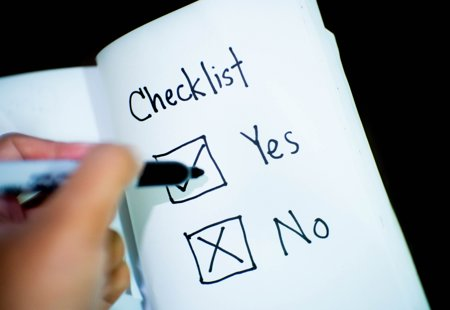 close-up photo of someone about to tick one of two boxes in a notebook marked 'yes' and 'no'