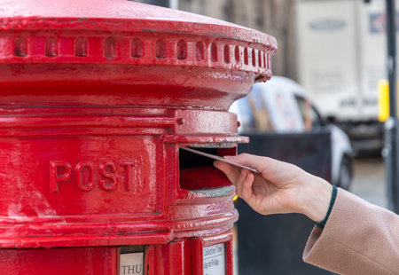 close up hand holding red mailbox