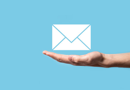 Photo of a hand being held out palm-up in front of a pale blue backround. An icon of an envelope is floating over the hand