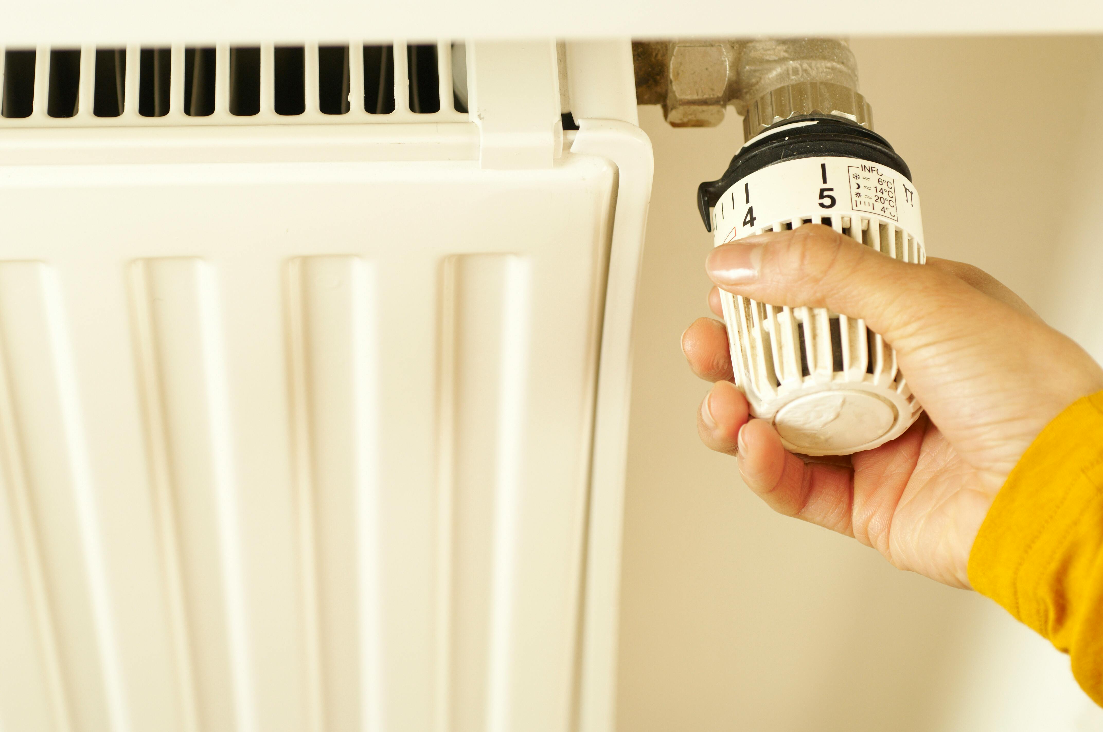 Person with hand on radiator dial
