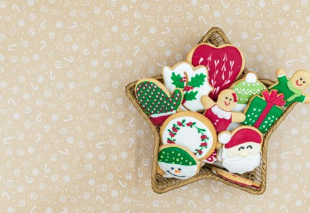 A selection of iced Christmas shaped biscuits in a star shaped basket