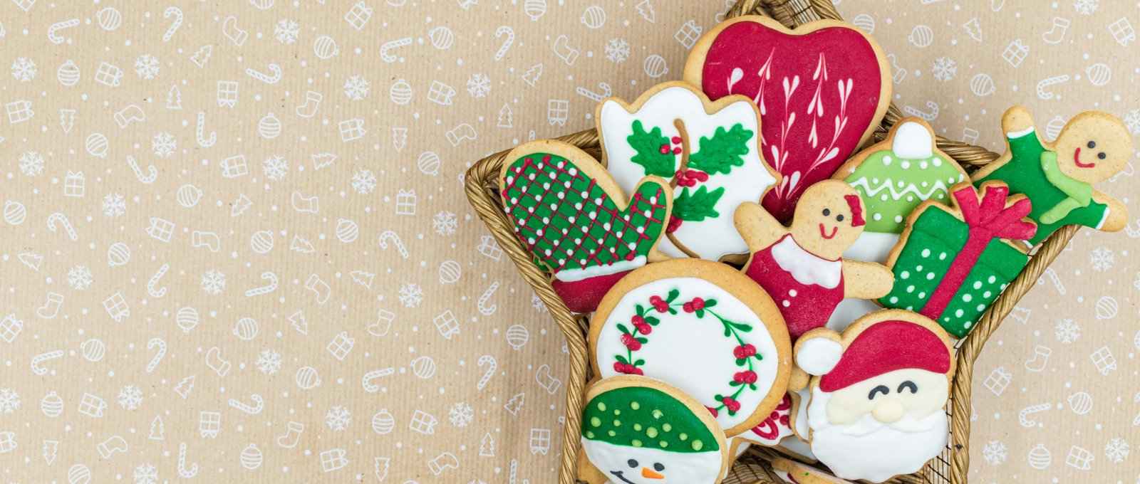 A selection of iced Christmas shaped biscuits in a star shaped basket