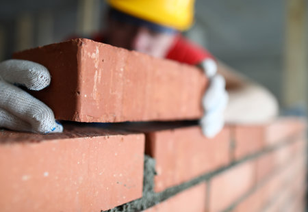 close up photo of a brick being added to a wall