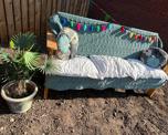 Wooden bench with a throw, cushions and decoration outside