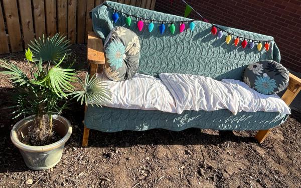 Wooden bench with a throw, cushions and decoration outside