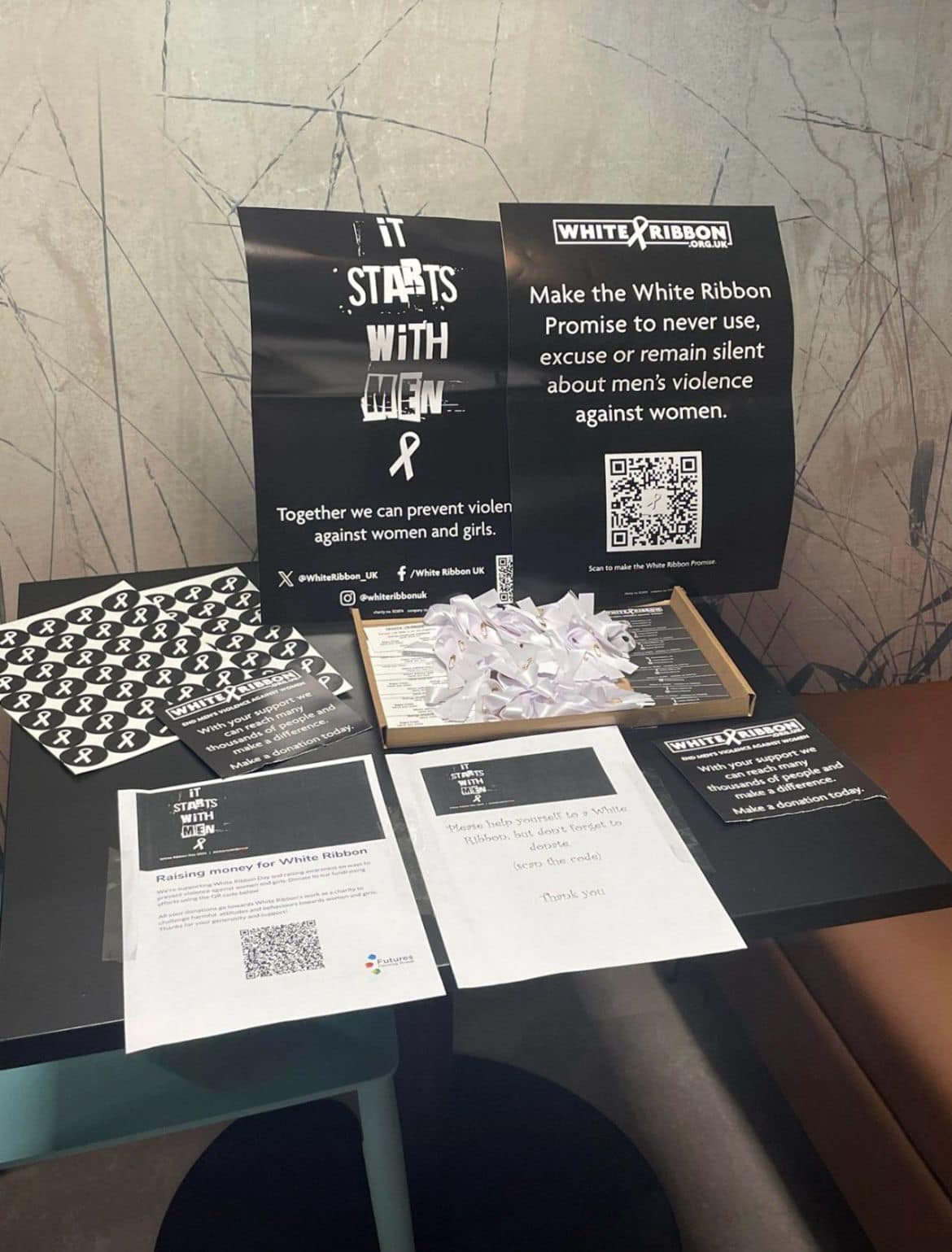 Photo of a table with lots of White Ribbon Day resources on