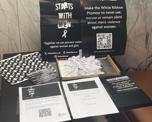 Photo of a table with lots of White Ribbon Day resources on