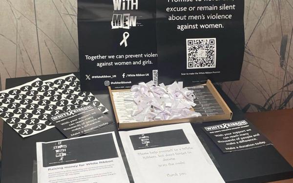 Photo of a table with lots of White Ribbon Day resources on