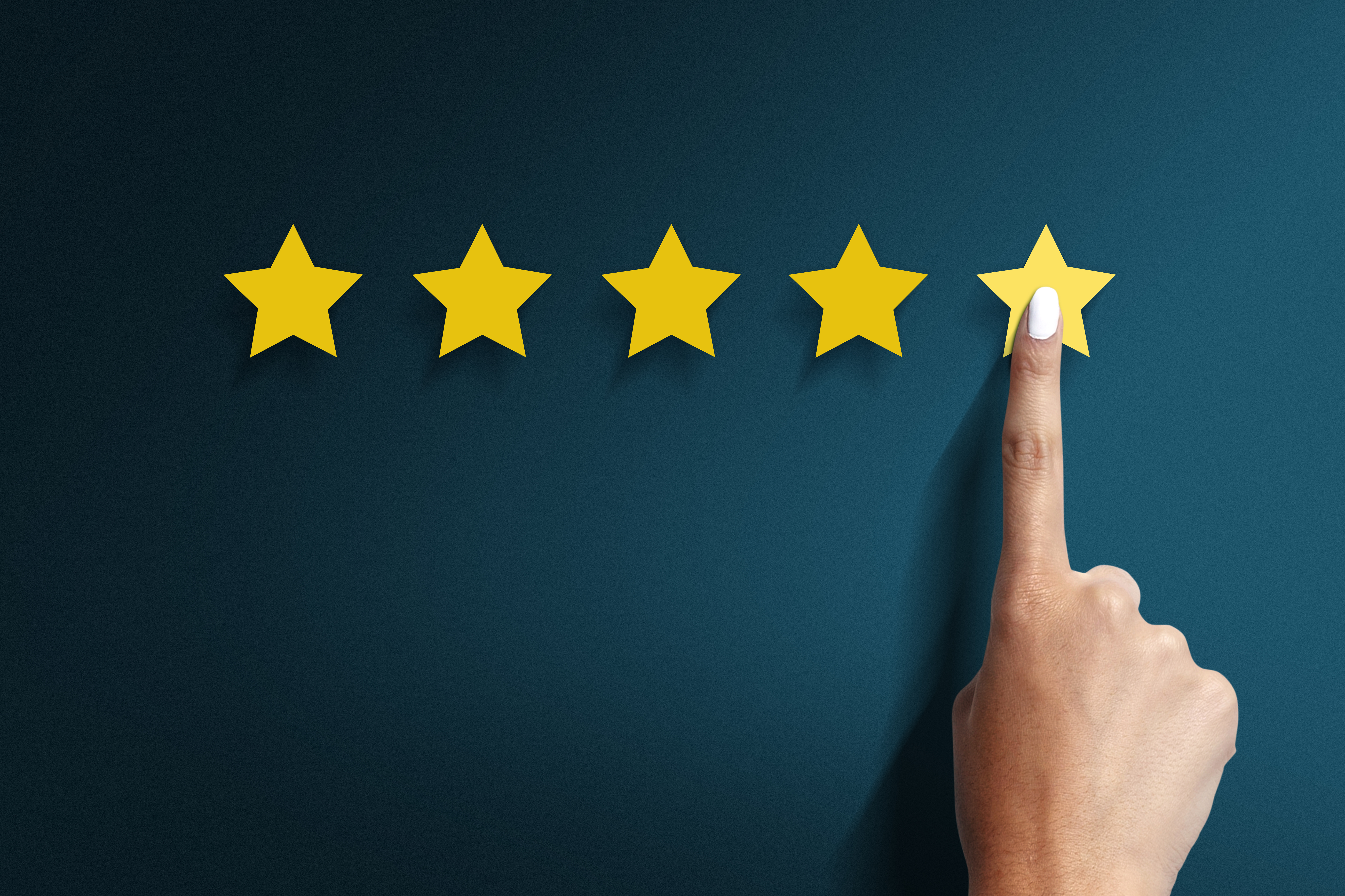 Five yellow stars on a dark blue background with a finger on the fifth star
