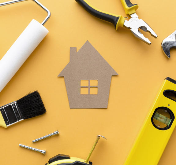 Photo of a cardboard cut-out of a house surrounded by various tools