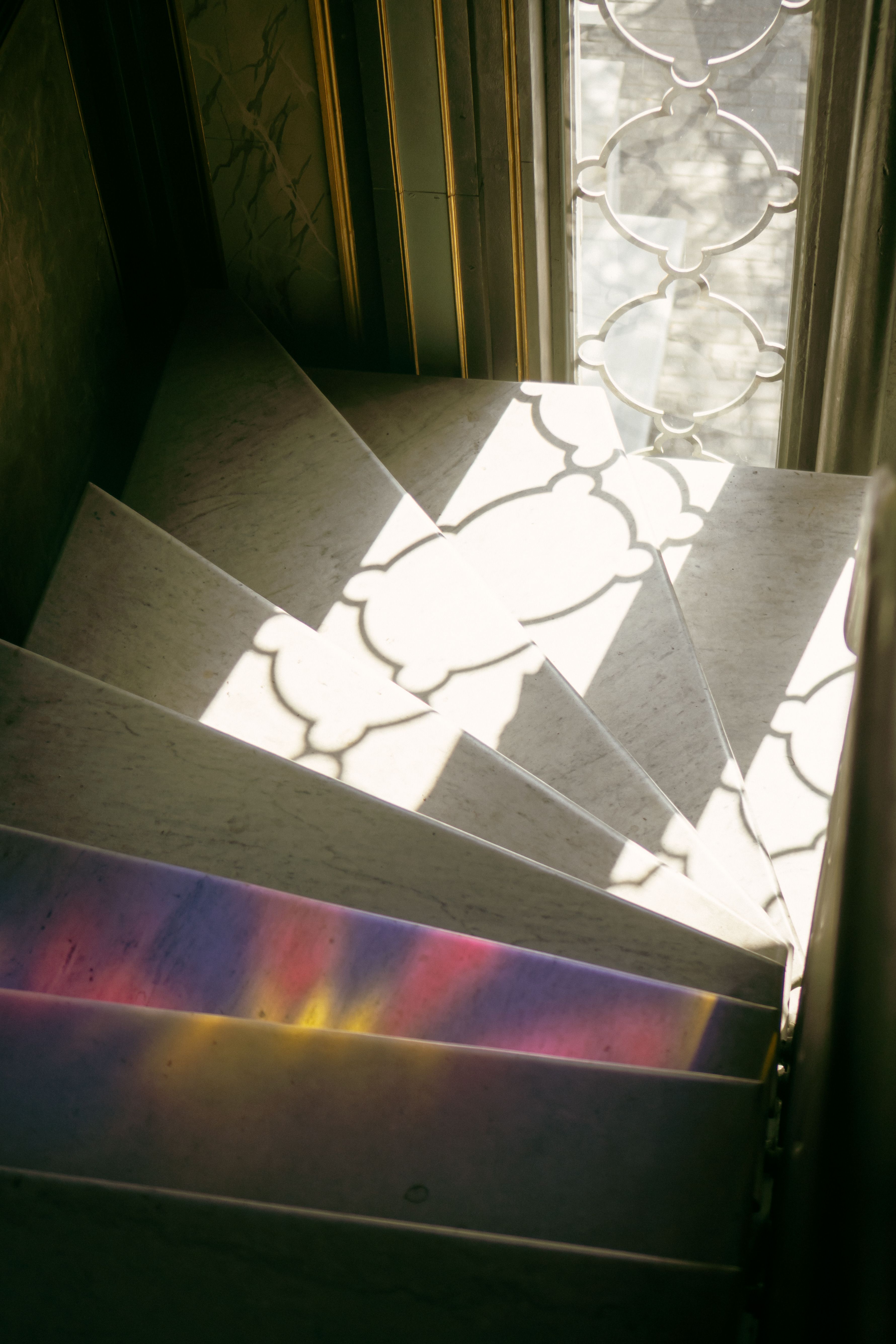 A light coloured staircase with light reflecting from a nearby window