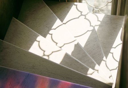 A light coloured staircase with light reflecting from a nearby window