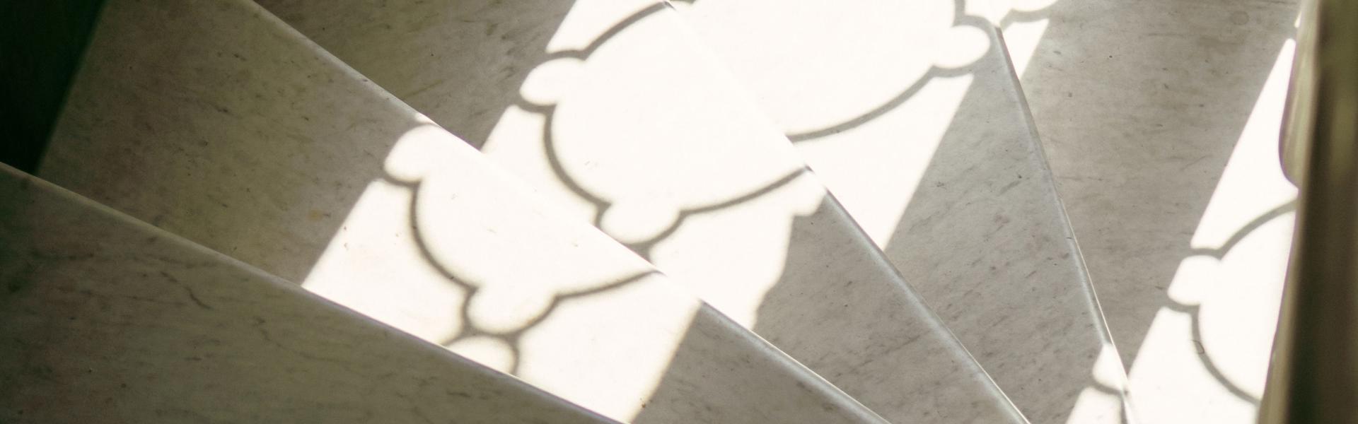 A light coloured staircase with light reflecting from a nearby window