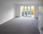 Photo of a plain white living room with french doors looking into garden