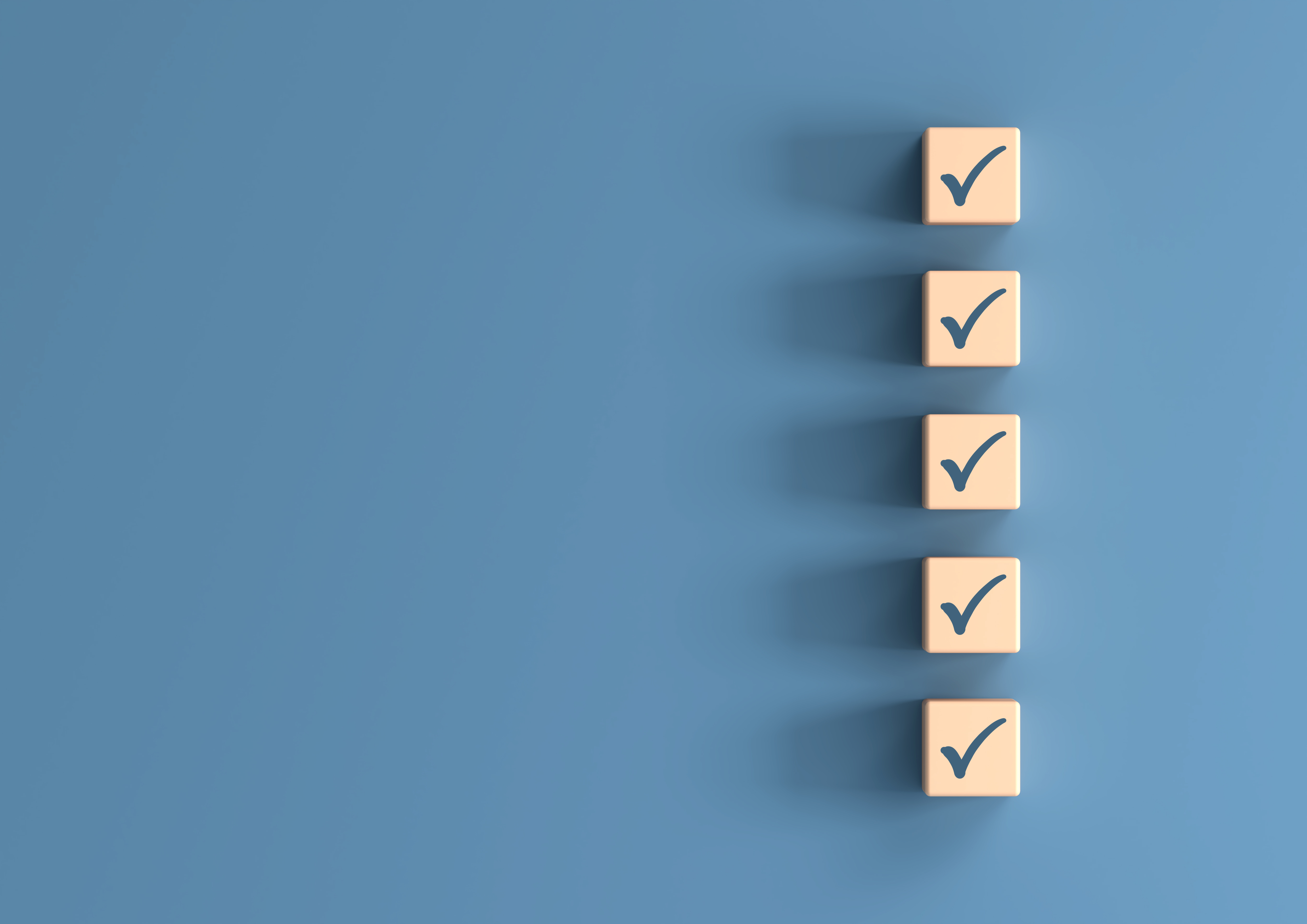 Photo of five cubes each with a tick on the top surface, all lined up on a blue background