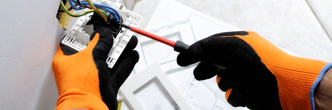 A pair of gloved hands replacing a fuse