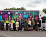 Group of partners and children with litter pickers and sports equipment