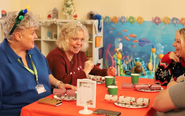 Photo of people sitting around a table with Christmas decorations on