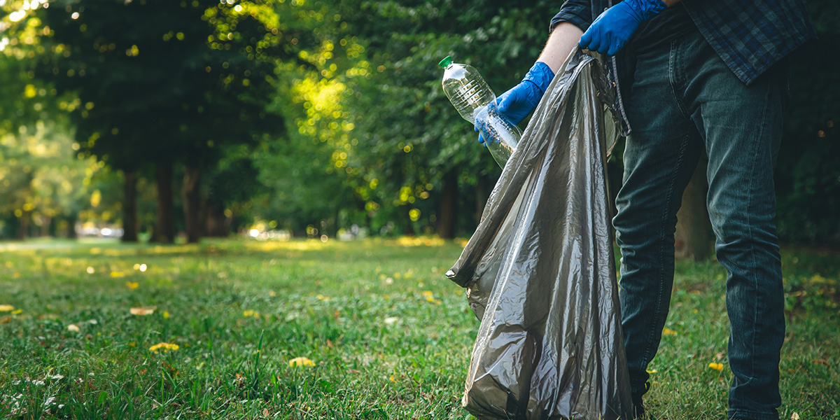 Man litter picking with a bin bag in a park