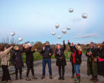Photo of a group of people letting go of balloons