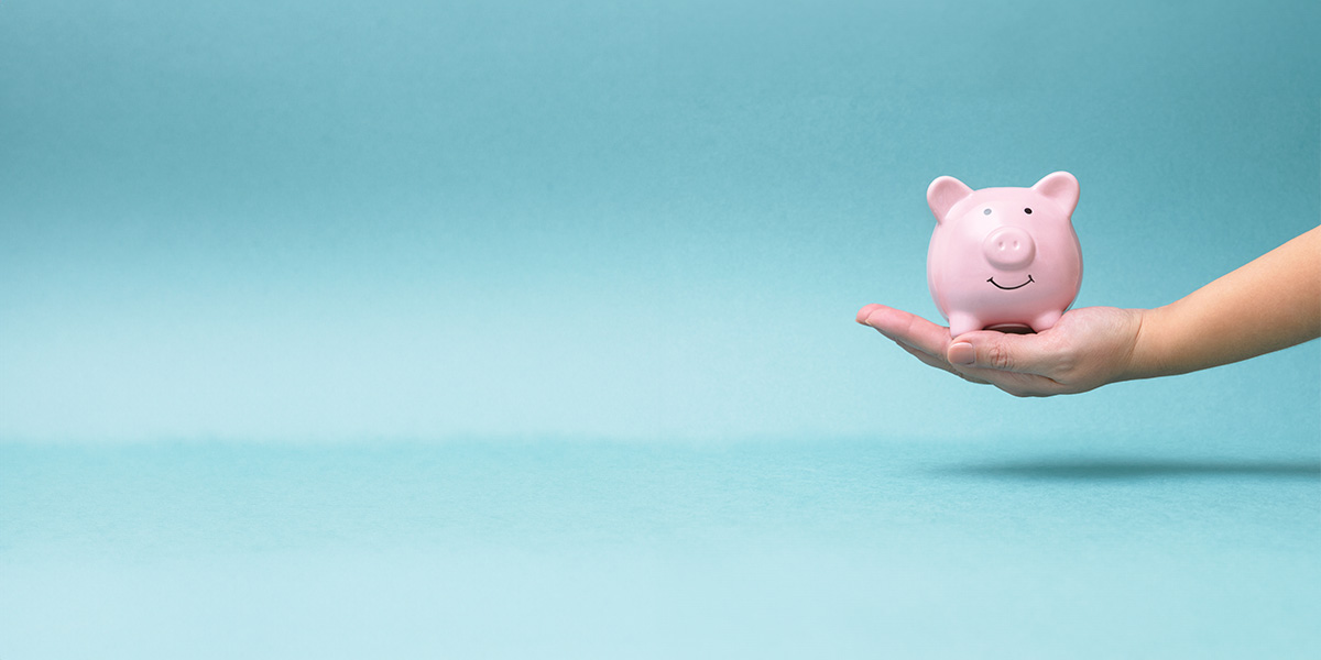 Hand Holding Pink Smiling Piggy Bank, Blue Background 2