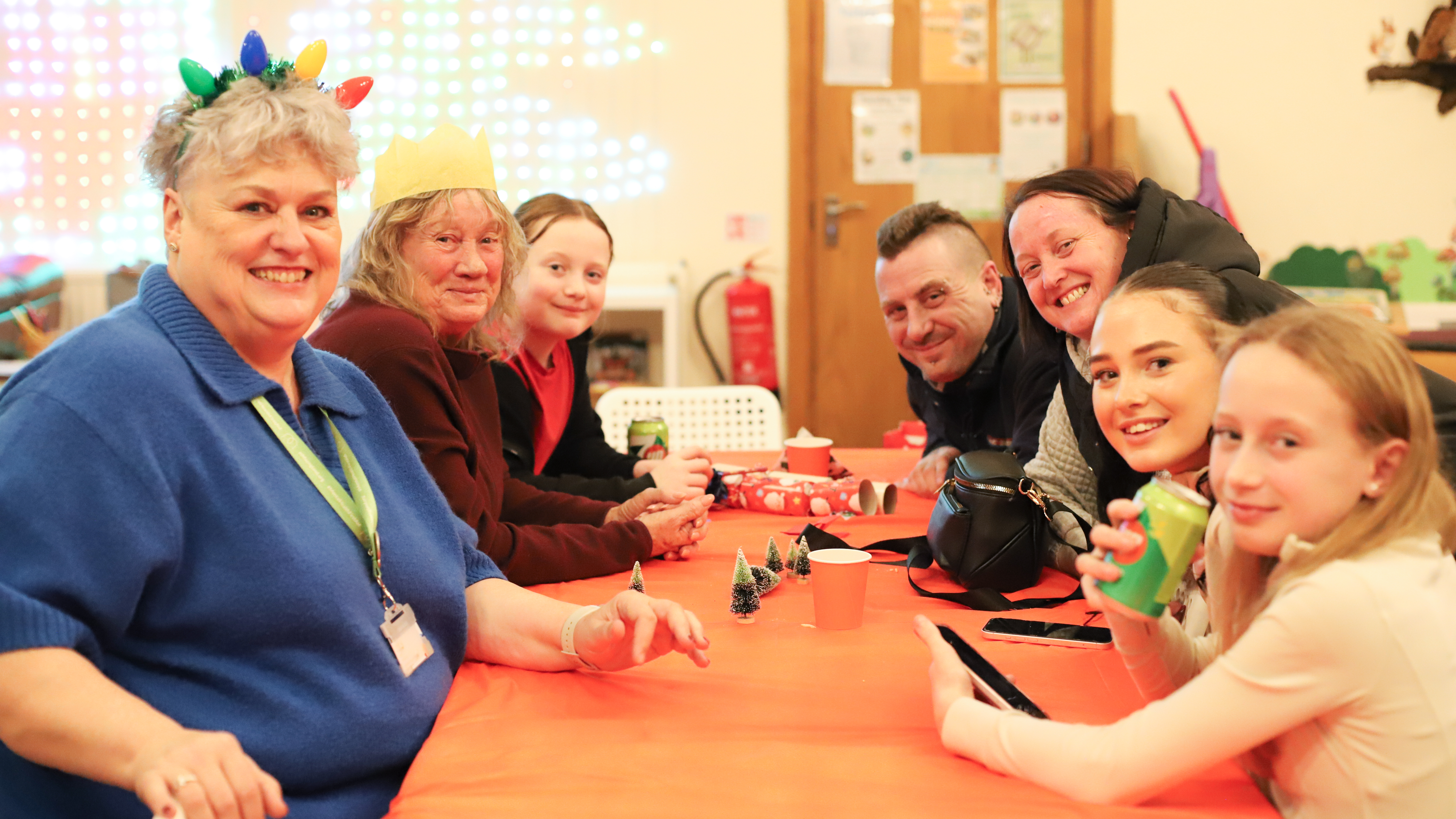 Photo of people sitting around a table with Christmas decorations on