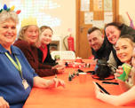 Photo of people sitting around a table with Christmas decorations on
