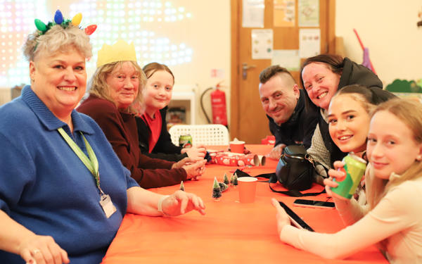 Photo of people sitting around a table with Christmas decorations on