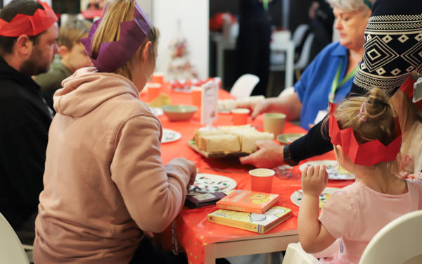 Photo of people sitting around a table with Christmas decorations on