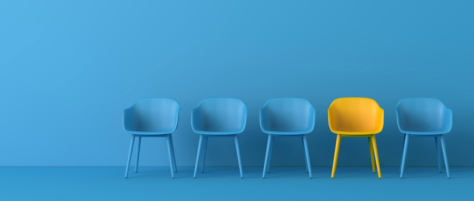 Photo of five chairs against a blue background. All are coloured blue to match the background except one which is bright yellow