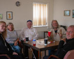 Photo of group of colleagues and customers sat around a table