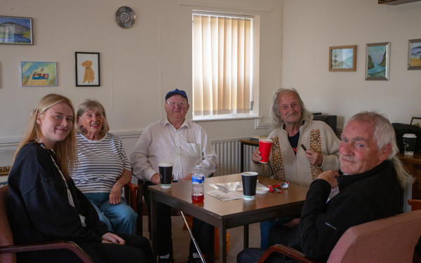 Photo of group of colleagues and customers sat around a table