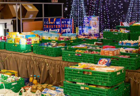 Crates of food on a stage with Christmas decorations in the background