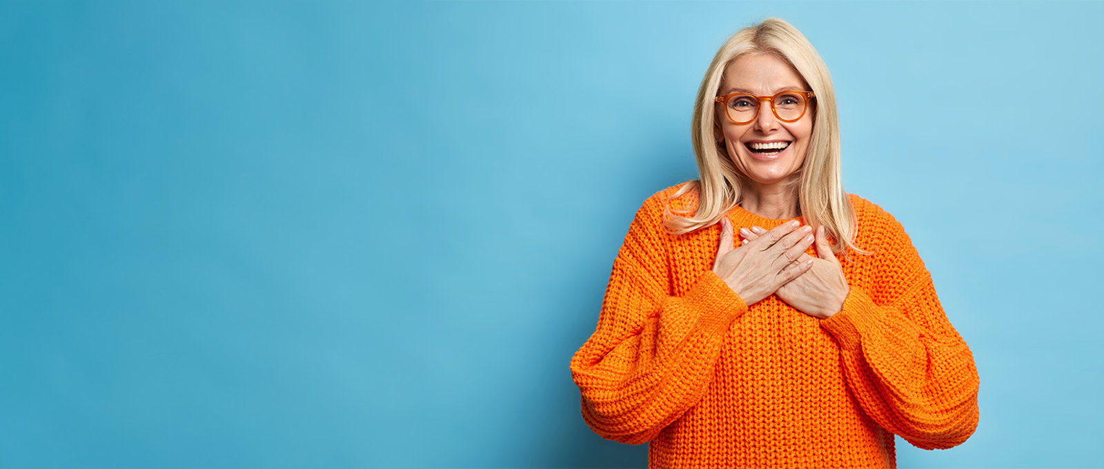 Smiling Woman With Glasses In Orange Jumper, Blue Background