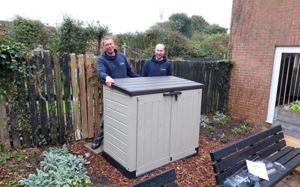 Colleagues with new storage unit outside