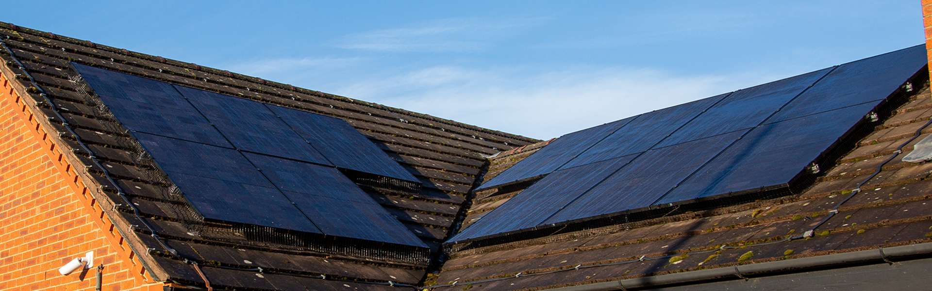 Photo of solar panels on top of a roof, blue sky