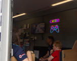 Child and colleagues playing Xbox inside a mobile van