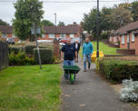 Colleague pushing an empty wheelbarrow outside