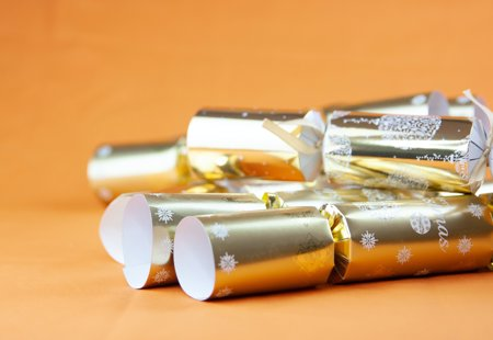 Gold Christmas crackers on an orange background